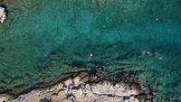 Pantai pun jadi destinasi utama dan populer bagi warga yang hendak mendinginkan tubuh di tengah hantaman gelombang panas.