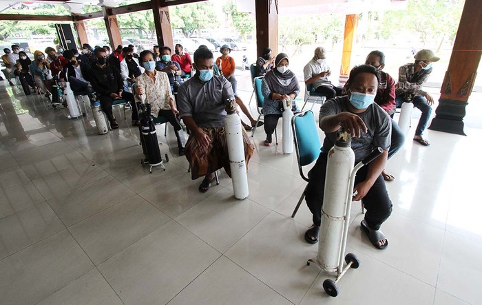 Warga mengantre untuk melakukan isi ulang oksigen pada kegiatan bakti sosial oksigen tanpa dipungut biaya di Rumah Dinas Bupati Karanganyar, Jawa Tengah, Jumat (30/7).