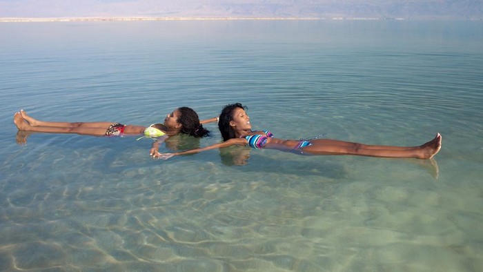Laut Mari, Dead Sea Lovely girls floating in salty water of Dead Sea. Unusual buoyancy caused by high salinity.