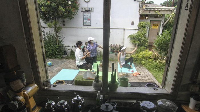 MINUM KOPI SAMBIL BERJEMUR Pekerja menyiapkan kopi untuk pengunjung yang berjemur di halaman sebuah kedai kopi di Depok, Jawa Barat, Jumat (30/7/2021). Kedai kopi tersebut menjadikan halamannya untuk program Ngopi Sambil Berjemur pada pukul 09.00 hingga pukul 10.00 WIB dengan pembatasan waktu 20 menit setiap pengunjung. ANTARA FOTO/Asprilla Dwi Adha/wsj.