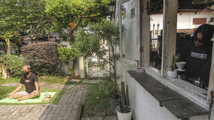 MINUM KOPI SAMBIL BERJEMUR Pekerja menyiapkan kopi untuk pengunjung yang berjemur di halaman sebuah kedai kopi di Depok, Jawa Barat, Jumat (30/7/2021). Kedai kopi tersebut menjadikan halamannya untuk program Ngopi Sambil Berjemur pada pukul 09.00 hingga pukul 10.00 WIB dengan pembatasan waktu 20 menit setiap pengunjung. ANTARA FOTO/Asprilla Dwi Adha/wsj.