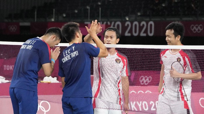 Taiwans Lee Yang, center left, and Wang Chi-Lin, left, talk to Indonesias Mohammad Ahsan and Hendra Setiawan after wining their mens doubles badminton semifinal match against them at the 2020 Summer Olympics, Friday, July 30, 2021, in Tokyo, Japan. (AP Photo/Markus Schreiber)