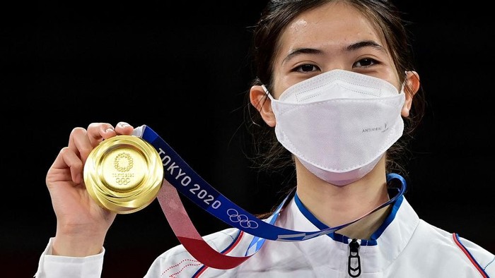 Thailand's Panipak Wongpattanakit celebrates with her gold medal on the podium after winning the taekwondo women's -49kg gold medal bout during the Tokyo 2020 Olympic Games at the Makuhari Messe Hall in Tokyo on July 24, 2021. (Photo by Javier SORIANO / AFP)