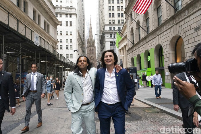 Baiju Bhatt, left, and Vladimir Tenev, Co-Founders of Robinhood, walk on Wall Street following their company's IPO at Nasdaq, Thursday, July 29, 2021 in New York. Robinhood is selling its own stock on Wall Street, the very place the online brokerage has rattled with its stated goal of democratizing finance. Through its app, Robinhood has introduced millions to investing and reshaped the brokerage industry, all while racking up a long list of controversies in less than eight years. (AP Photo/Mark Lennihan)
