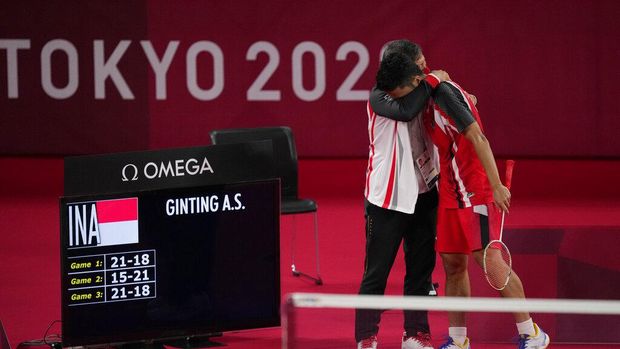 Indonesia's Anthony Sinisuka Ginting celebrates with his coach Henry Saputra Ho after defeating Anders Antonsen of Denmark during their men's singles badminton quarterfinal match at the 2020 Summer Olympics, Saturday, July 31, 2021, in Tokyo, Japan. (AP Photo/Dita Alangkara)