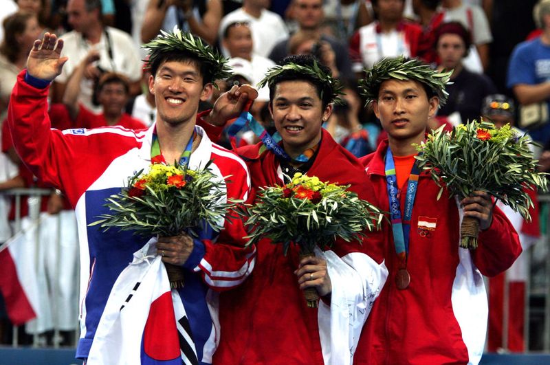 ATHENS - AUGUST 21: (L-R) Seung Mo Shon of Korea (silver), Taufik Hidayat of Indonesia (gold) and Soni Dwi Kuncoro of Indonesia (bronze) celebrate after receiving medals for the men's singles badminton event on August 21, 2004 during the Athens 2004 Summer Olympic Games at Olympic Hall in the Goudi Olympic Complex in Athens, Greece. (Photo by Jonathan Ferrey/Getty Images)