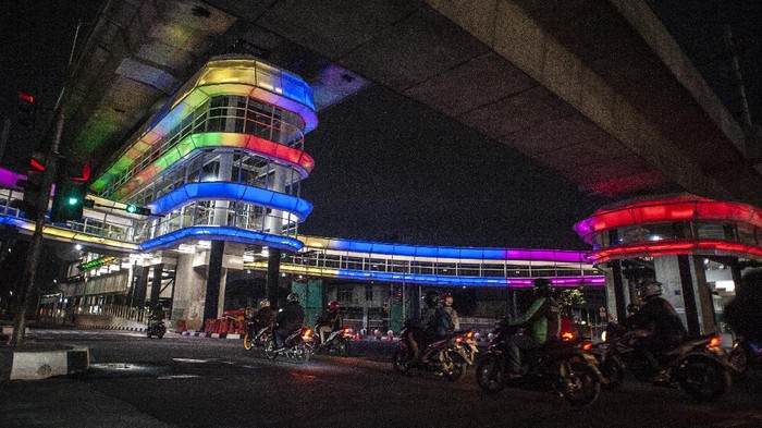 Seorang perempuan duduk di atas pembatas jalan di dekat halte Centrale Stichting Wederopbouw (CSW) yang berhiaskan lampu warna-warni di Kawasan Kebayoran Baru, Jakarta, Sabtu (31/7/2021). Proyek pembangunan jembatan penghubung atau skybridge untuk intergrasi Halte Transjakarta CSW dengan Stasiun MRT ASEAN itu mengusung konsep desain Cakra Selaras Wahana yang memiliki arti sebagai lingkaran penghubung yang setara antar moda. ANTARA FOTO/Aprillio Akbar/wsj.