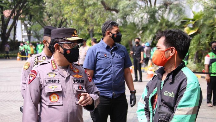 Kapolri Jenderal Listyo Sigit Prabowo berbincang dengan driver ojol di lokasi penyaluran bansos online