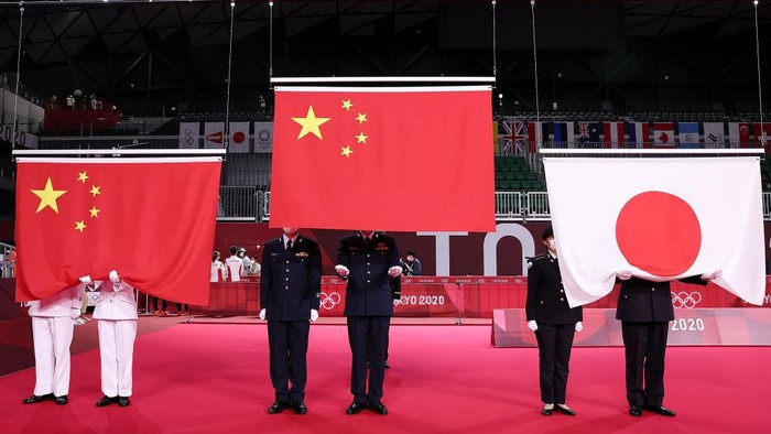 CHOFU, JAPAN - JULY 30: National flags of China and Japan are prepared to be raised during the medal ceremony for the Mix Doubles badminton event on day seven of the Tokyo 2020 Olympic Games at Musashino Forest Sport Plaza on July 30, 2021 in Chofu, Tokyo, Japan. (Photo by Lintao Zhang/Getty Images)