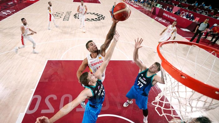 SAITAMA, JAPAN - AUGUST 01: Willy Hernangomez #14 of Team Spain goes up for a rebound against Luka Doncic #77 and Vlatko Cancar #31 of Team Slovenia during the first half of a Mens Basketball Preliminary Round Group C game at Saitama Super Arena on August 01, 2021 in Saitama, Japan. (Photo by Charlie Neibergall - Pool/Getty Images)