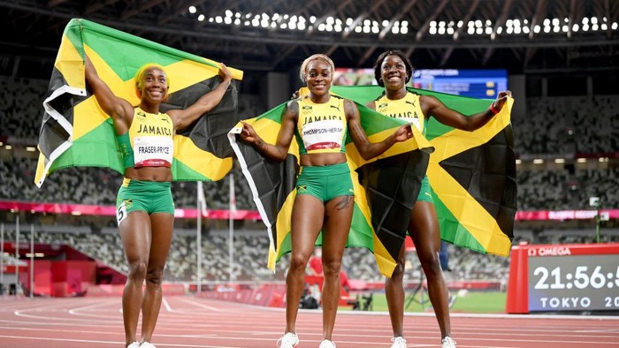 TOKYO, JAPAN - JULY 31: (L-R) Shelly-Ann Fraser-Pryce, Elaine Thompson-Herah and Shericka Jackson of Team Jamaica celebrate after completing a podium sweep in the Womens 100m Final on day eight of the Tokyo 2020 Olympic Games at Olympic Stadium on July 31, 2021 in Tokyo, Japan. (Photo by Matthias Hangst/Getty Images)