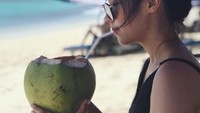 Liburan ke Bali, Olivia menikmati seganya kelapa muda di pinggir pantai. Foto: Instagram @olivia.mci8
