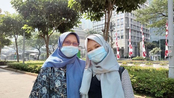 Hana (kanan) bersama ibunya, Ninik (kiri) berharap PPKM level 4 di Jakarta tak diperpanjang, Jl Sudirman, Jakarta, Minggu (1/8/2021).