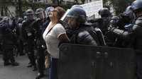 Aksi unjuk rasa yang mulanya berlangsung damai itu pun berujung ricuh. Sejumlah demonstran tampak diamankan oleh petugas kepolisian. AP Photo/Adrienne Surprenant. 
