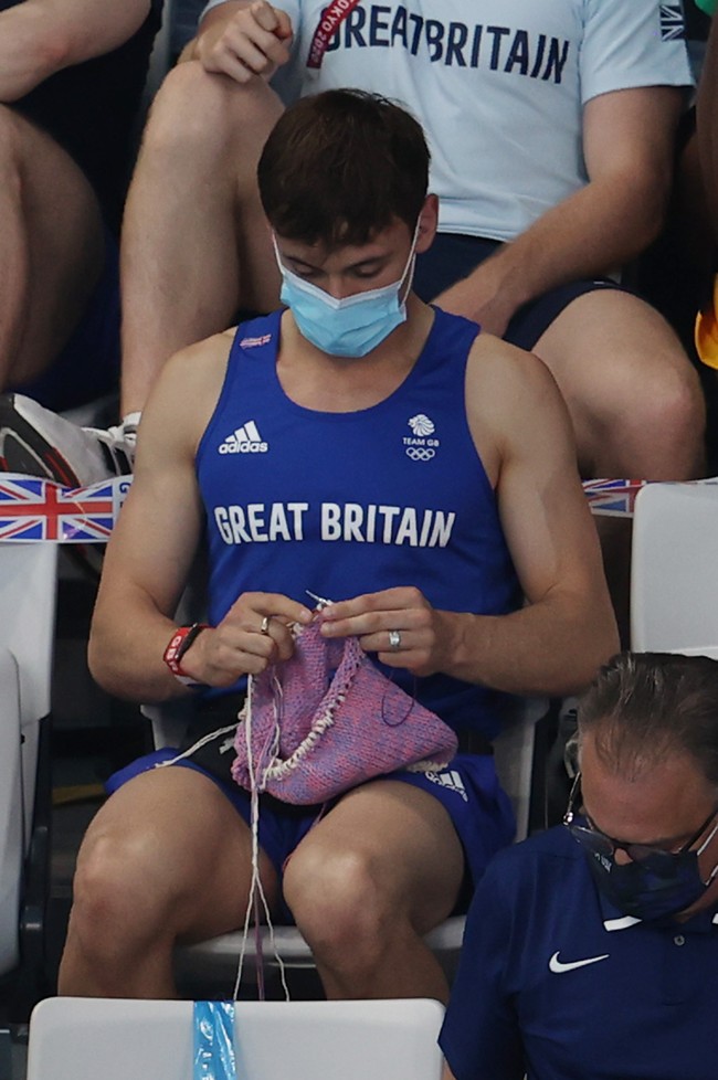 Sebuah pemandangan unik terlihat dalam pertandingan loncat indah wanita di Olimpiade Tokyo 2020. Atlet kenamaan Tom Daley kedapatan menonton laga tersebut selagi tangannya sibuk merajut benang. Foto: Getty Images/Clive Rose