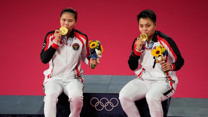 Gold medalists Greysia Polii, left, and Apriyani Rahayu from Indonesia celebrate during the medals ceremony of the womens doubles gold medal match at the 2020 Summer Olympics, Monday, Aug. 2, 2021, in Tokyo, Japan. (AP Photo/Markus Schreiber)