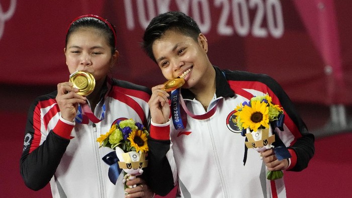 Gold medalists Greysia Polii, left, and Apriyani Rahayu from Indonesia celebrate during the medals ceremony of the womens doubles gold medal match at the 2020 Summer Olympics, Monday, Aug. 2, 2021, in Tokyo, Japan. (AP Photo/Markus Schreiber)