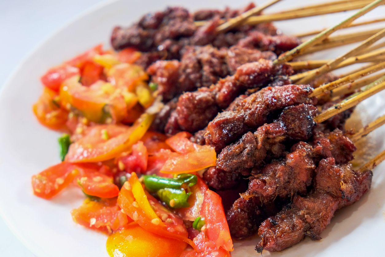 Close up shot of tasty lamb satay with chopped tomatoes and chili for eid al-adha dinner meal