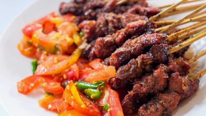 Close up shot of tasty lamb satay with chopped tomatoes and chili for eid al-adha dinner meal
