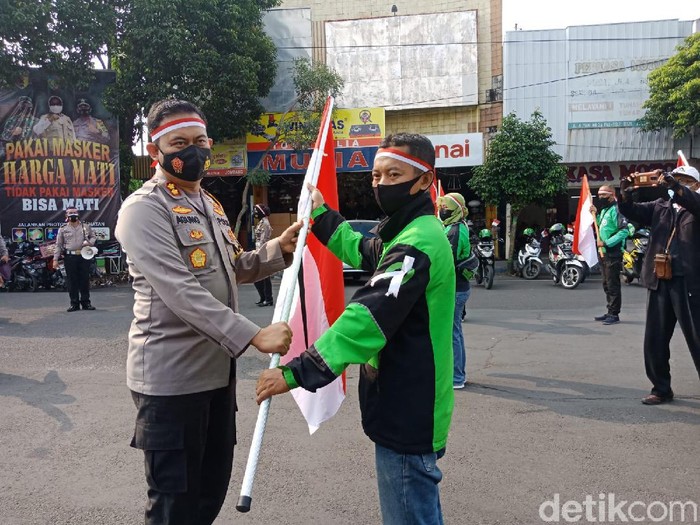Para PKL dan ojol di Jombang diajak mengibarkan Bendera Merah Putih. Aksi ini untuk menggelorakan semangat perjuangan melawan pandemi COVID-19.