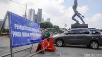 Papan pengumuman PPKM masih terpasang di pinggir jalan di kawasan Bundaran HI.
