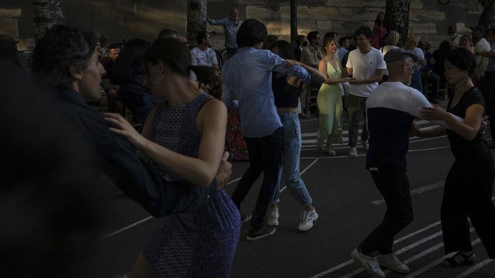 People dance swing on the rhythms of a live band by the restaurant Le Marcounet, in Paris, Sunday, Aug. 1, 2021. The sanitary pass, which proves someone has been vaccinated or recently done a test or recovered from Covid-19, will be mandatory in bars and restaurants, cultural venues of more than 50 people, museums, shopping malls and for long distance travels. (AP Photo/Adrienne Surprenant)