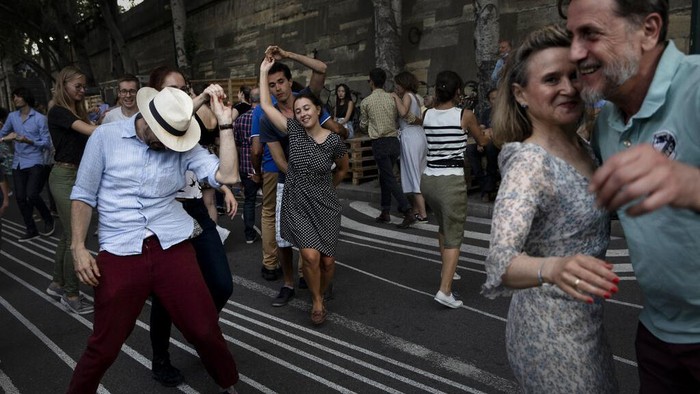 People dance swing on the rhythms of a live band by the restaurant Le Marcounet, in Paris, Sunday, Aug. 1, 2021. The sanitary pass, which proves someone has been vaccinated or recently done a test or recovered from Covid-19, will be mandatory in bars and restaurants, cultural venues of more than 50 people, museums, shopping malls and for long distance travels. (AP Photo/Adrienne Surprenant)