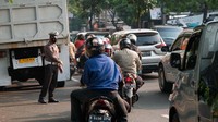 Polisi membantu mengurai kemacetan di lokasi. Usai lokasi truk mogok, lalin kembali lancar.