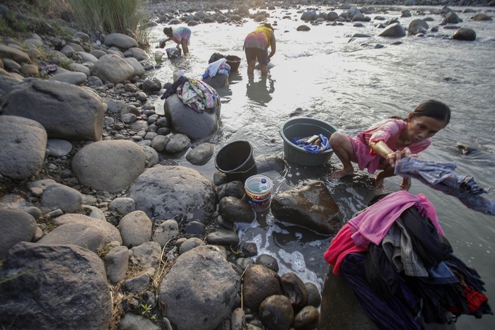 Warga mencuci pakaian di aliran Sungai Cipamingkis yang menyusut di Jonggol, Kabupaten Bogor, Jawa Barat, Selasa (3/8/2021). Warga setempat terpaksa memanfaatkan aliran Sungai Cipamingkis untuk kegiatan mandi, cuci dan kakus (MCK) karena air sumur di rumah mereka mengalami kekeringan sejak satu bulan lalu. ANTARA FOTO/Yulius Satria Wijaya/rwa.