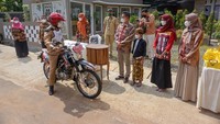 Bupati Batang Wihaji (kedua kiri) mengendarai sepeda motor menghadiri acara khitan dengan sistem drive thru di Desa Tambahrejo, Bandar, Kabupaten Batang, Jawa Tengah, Selasa (3/8/2021).  