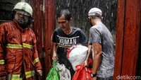 Sejumlah warga tampak mencoba menyelamatkan barang-barang berharga usai rumahnya dilalap si jago merah.