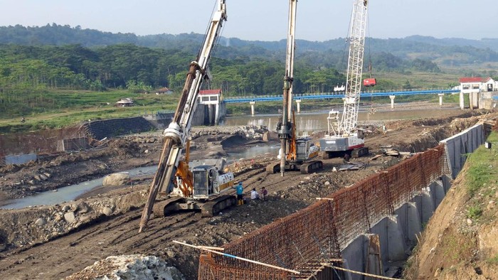 Pekerja menyelesaikan pembangunan Bendungan Cipamingkis di Jonggol, Kabupaten Bogor, Jawa Barat, Selasa (3/8/2021). Pembangunan bendungan baru untuk menggantikan bendungan lama yang jebol pada 2017 lalu itu mengembalikan fungsi Bendung Cipamingkis sebagai suplai air irigasi kebutuhan lahan persawahan masyarakat di Kabupaten Bogor dan Kabupaten BekasI dengan target selesai tahun 2022. ANTARA FOTO/Yulius Satria Wijaya/rwa.