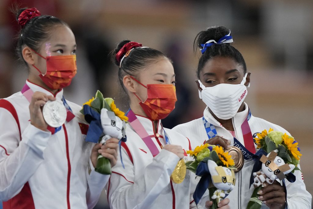 From left, silver medallist Tang Xijing, of China, gold medallist Guan Chenchen, of China, and bronze medallist Simone Biles, of the United States, pose with their medals for the balance beam during the artistic gymnastics women's apparatus final at the 2020 Summer Olympics, Tuesday, Aug. 3, 2021, in Tokyo, Japan. (AP Photo/Natacha Pisarenko)