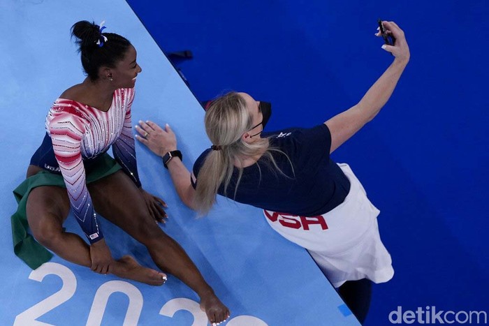 Tokyo Olympics Artistic Gymnastics Coach Cecile Landi takes a selfie with Simone Biles, of the United States, during the warm up prior to the artistic gymnastics balance beam final at the 2020 Summer Olympics, Tuesday, Aug. 3, 2021, in Tokyo, Japan. (AP Photo/Morry Gash)
