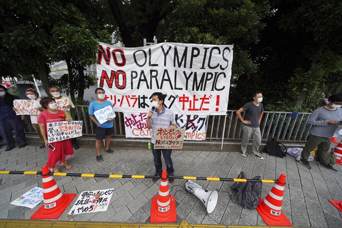 Protesters demonstrate in front of the Prime Minister's Office in Tokyo, Japan, Monday, Aug. 2, 2021. They were protesting against the Olympics and Paralympics held during the pandemic as Japan has expanded a coronavirus state of emergency to Tokyo's neighboring prefectures in addition to the capital, following recent record spikes in infections. (AP Photo/Kantaro Komiya)