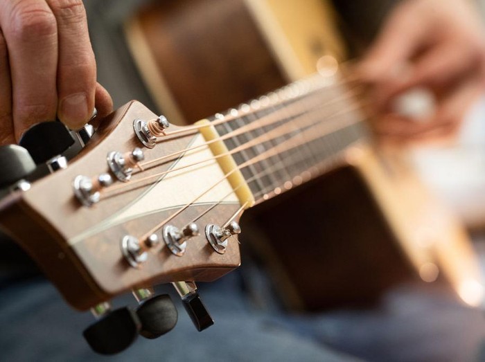 1195447328 REMAGEN, GERMANY - DECEMBER 11: Master guitar craftsman Tobias Ahlke adjusts the tones on an acoustic guitar body at his workshop on December 11, 2019 in Remagen, Germany. Germany. Ahlke produces acoustic and electric guitars from carefully selected types of wood and needs about 100 working hours to produce a single acoustic guitar. His clients wait up to a year for his Essence brand of custom-made guitars. (Photo by Andreas Rentz/Getty Images)