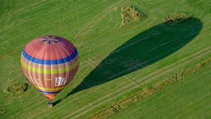 1332282823 BRISTOL, ENGLAND - AUGUST 04: A person adjusts some lines inside a hot-air balloon before take off on August 04, 2021 in Bristol, England.