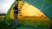 Seorang warga bersiap menerbangkan balon udara.