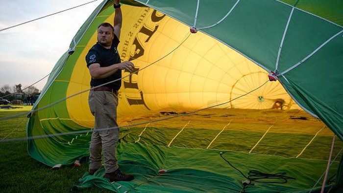 BRISTOL, ENGLAND - AUGUST 04: A person adjusts some lines inside a hot-air balloon before take off on August 04, 2021 in Bristol, England. 