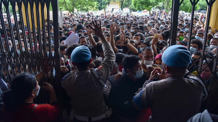 Warga antre untuk melakukan vaksinasi di aula Gedung Serbaguna Pemprov Sumatera Utara, Kota Medan, Selasa (3/8/2021). Ratusan warga berdesakan untuk mengikuti vaksinasi yang diselenggarakan oleh Polda Sumatera Utara. ANTARA FOTO/Fransisco Carolio/Lmo/hp.