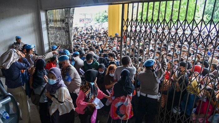 Warga antre untuk melakukan vaksinasi di aula Gedung Serbaguna Pemprov Sumatera Utara, Kota Medan, Selasa (3/8/2021). Ratusan warga berdesakan untuk mengikuti vaksinasi yang diselenggarakan oleh Polda Sumatera Utara. ANTARA FOTO/Fransisco Carolio/Lmo/hp.
