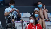 Atlet berprestasi yang secara terbuka mengaku gay tersebut terlihat sibuk merajut benang di kursi penonton. Clive Rose/Getty Images.