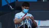 Tom Daley tampak sibuk sambil merajut benang di sela-sela menonton pertandingan loncat indah wanita di Olimpiade Tokyo 2020. Clive Rose/Getty Images.