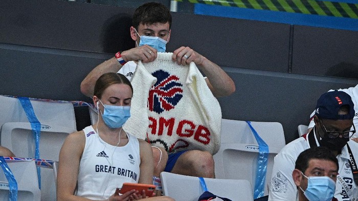 British diver Thomas Daley sits with his knitting as he watches divers in the preliminary round of the men's 3m springboard diving event during the Tokyo 2020 Olympic Games at the Tokyo Aquatics Centre in Tokyo on August 2, 2021. (Photo by Oli SCARFF / AFP)