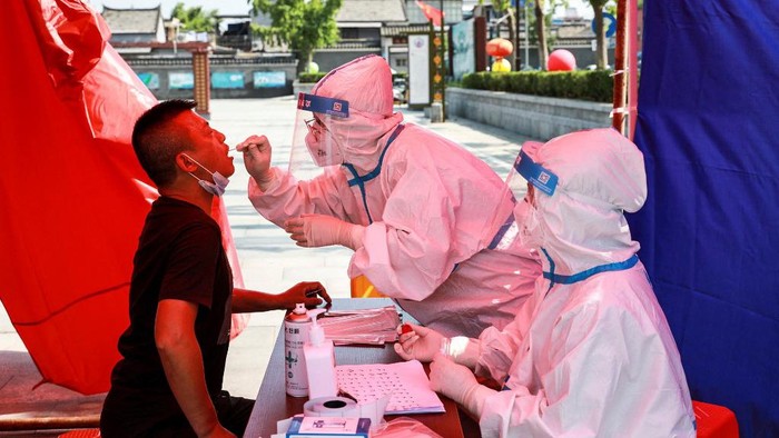 The photo taken on July 30, 2021 shows a man receiving nucleic acid testing for the Covid-19 coronavirus in Huaian, in eastern Chinas Jiangsu province, as China raced to contain its worst coronavirus outbreak in months. (Photo by STR / AFP) / China OUT