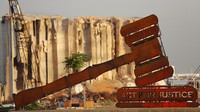 Sebuah monumen simbol keadilan terlihat di depan gudang yang hancur dalam ledakan besar di pelabuhan Beirut, Lebanon, Rabu (4/8/2020). AP Photo/Hussein Malla  
