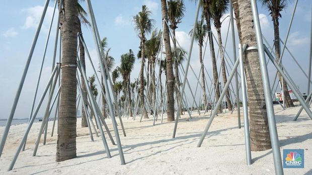Suasana pantai pasir putih di Kawasan PIK 2, Dadap, Tangerang, Banten, Rabu (4/8/2021). Pantai Pasir Putih di kawasan Pantai Indah Kapuk tengah populer di kalangan traveler. Semenjak dibuka tahun 2020 lalu, tak sedikit traveler yang singgah ke Pantai Pasir Putih kala bertandang ke PIK. Di tengah kondisi pandemi, destinasi outdoor ini memang jadi primadona. Kini sejak diberlakukan PPKM darurat level 4 terlihat kawasan pasir putih sepi pengunjung. Hanya beberapa perahu nelayan yang sedang mencari  ikan di perairan laut pasir putih. Apabila PIK pertama berada di Provinsi DKI Jakarta, maka Pantai Pasir Putih di PIK2 masuk ke Provinsi Banten. (CNBC Indonesia/ Muhammad Sabki)