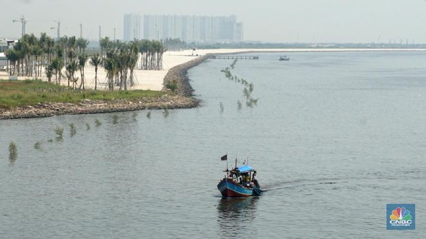Suasana pantai pasir putih di Kawasan PIK 2, Dadap, Tangerang, Banten, Rabu (4/8/2021). Pantai Pasir Putih di kawasan Pantai Indah Kapuk tengah populer di kalangan traveler. Semenjak dibuka tahun 2020 lalu, tak sedikit traveler yang singgah ke Pantai Pasir Putih kala bertandang ke PIK. Di tengah kondisi pandemi, destinasi outdoor ini memang jadi primadona. Kini sejak diberlakukan PPKM darurat level 4 terlihat kawasan pasir putih sepi pengunjung. Hanya beberapa perahu nelayan yang sedang mencari  ikan di perairan laut pasir putih. Apabila PIK pertama berada di Provinsi DKI Jakarta, maka Pantai Pasir Putih di PIK2 masuk ke Provinsi Banten. (CNBC Indonesia/ Muhammad Sabki)