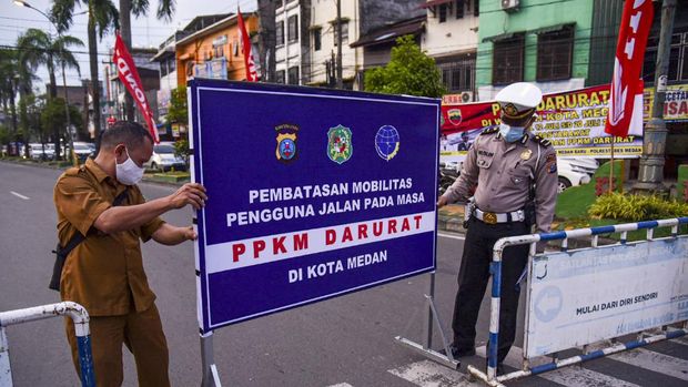 Personel Kepolisian memasang rambu penyekatan Pemberlakuan Pembatasan Kegiatan Masyarakat (PPKM) Darurat di Pertigaan Simpang Kampus USU, Medan Baru, Kota Medan, Sumatera Utara, Senin (12/7/2021). Penyekatan tersebut dalam rangka mengurangi mobilitas warga demi mengurangi angka penyebaran COVID-19 selama pemberlakuan PPKM Darurat di Kota Medan. ANTARA FOTO/Fransisco Carolio/Lmo/foc.
