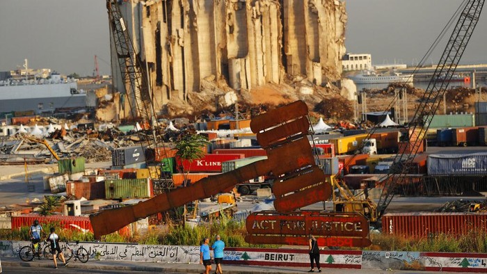 Satu Tahun Ledakan Beirut yang Menyisakan Luka Banners hang on buildings that were damaged during last year's seaport explosion during a commemoration in Beirut, Lebanon, Wednesday, Aug. 4, 2021. Lebanon is marking one year since the horrific explosion at Beirut port. The grim anniversary Wednesday comes amid an unprecedented economic and financial meltdown and a political stalemate that has kept the country without a functioning government for a full year. (AP Photo/Hussein Malla)
